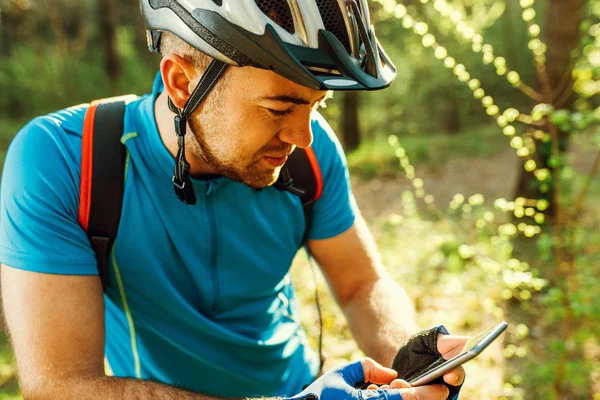 Vackra skott av cyklist på cykel med navigator på sin enhet, utforska kartan och Sök GPS-koordinater på mobil medan Cykling i bergen. Resor, sport, aktiv livsstil och modern teknik. — Stockfoto