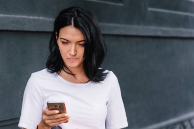Şık giysiler içinde iyi haber üstünde hareket eden telefon açık havada, yüksek hızlı internet bağlantısı ile kadın arıyorum iyi okur. Genç kız iletileri sosyal ağlar. Kişi, yaşam tarzı ve iş kavramı.