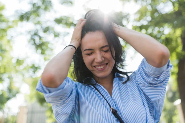 Belo tiro de mulher positiva em blusa azul com expressão feliz. Senhora elegante posando ao ar livre no parque enquanto descansa, fazendo cara engraçada. Estilo de vida e conceito de pessoas . — Fotografia de Stock