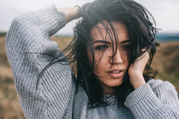 Retrato de close-up de mulher morena romântica posando contra a natureza, fundo do prado com cabelo ventoso. Pessoas e conceito de estilo de vida. Sensual fêmea natural posando durante a viagem. Ideia de capa humor . — Fotografia de Stock