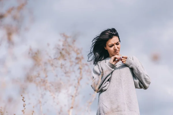 Ditembak dari brunette menarik penjelajah wanita muda Kaukasia dengan rambut berangin, berpose melawan langit mendung. Wanita impian dengan mata tertutup penarik abu-abu dengan ruang fotokopi. Konsep gaya hidup dan manusia . — Stok Foto