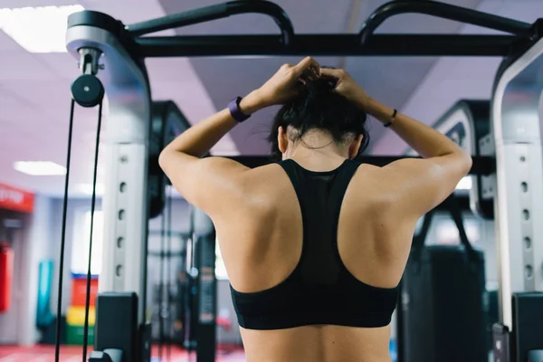 Rear view of strong Caucasian brunette woman is doing exercises with the bar in the gym, sporty woman preparing for exercises with barbell in gym. Bodybuilding, people, lifestyle and sport concept. — Stock Photo, Image
