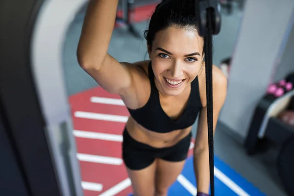 Widok góry piękny uśmiech kaukaskim kobieta brunetka robi ćwiczenia z paskiem siłownia sportowy kobieta ćwiczenia ze sztangą, siłownia, Kulturystyka, koncepcja ludzie i sport. — Zdjęcie stockowe