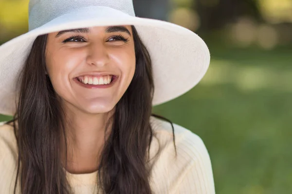 Retrato de perto recortado de feliz sorridente jovem mulher caucasiana vestindo um chapéu branco ao ar livre no parque. Estilo de vida e clima de celebração . — Fotografia de Stock