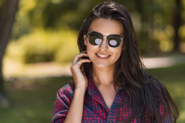 Гарний портрет щасливі молода брюнетка кавказьких жінки посміхається і носити сонцезахисні окуляри тлі природи в парку. Люди, спосіб життя і красу концепції. — стокове фото