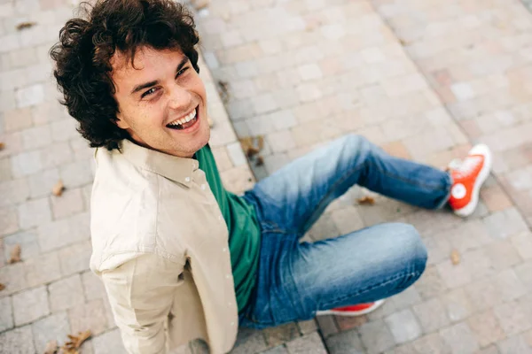 Jovem feliz e bonito sorrindo largamente posando para propaganda, sorrindo e olhando para a câmera. Retrato de estudante inteligente masculino tem expressão alegre . — Fotografia de Stock