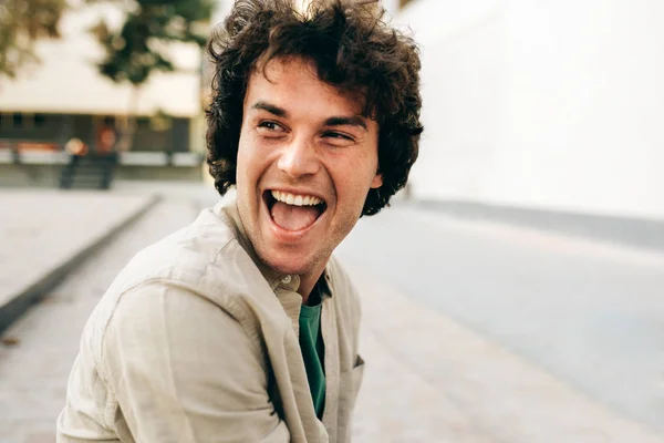 Közelkép egy jóképű, boldog fiatalemberről, aki széleskörűen mosolyog, reklámhoz pózol, mosolyog és a kamerába néz. A boldog diák férfi portréja örömteli arckifejezéssel bír.. — Stock Fotó
