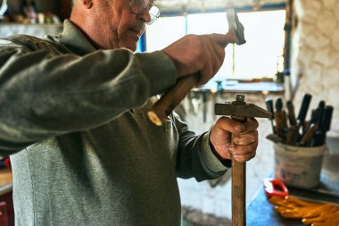 Yetişkin bir işçinin atölyesinde ürettiği yan görüntü..    