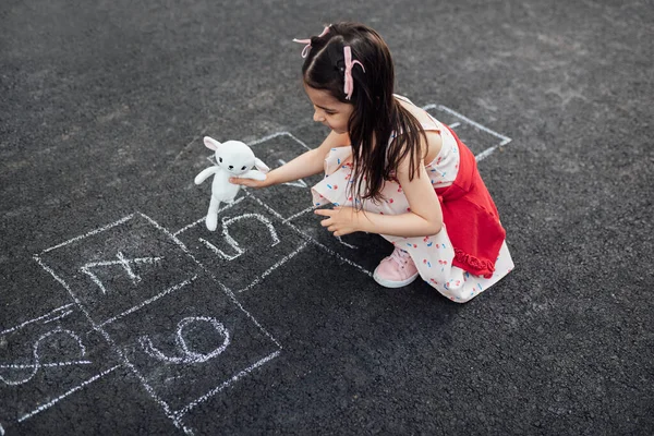 위에서는 놀이터에서 장난감 과놀고 소녀의 밖에서 있는아이 분필로 스카치를 그리면서 — 스톡 사진