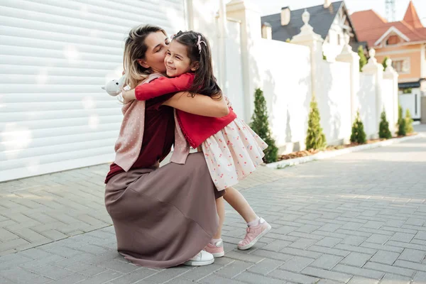 Annesinin Açık Hava Görüntüsü Okuldan Eve Dönen Küçük Kızını Kucaklıyor — Stok fotoğraf