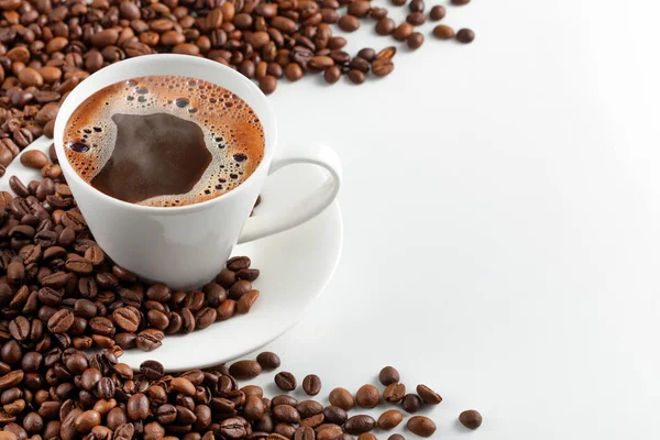 Una taza de café caliente con granos de café sobre un fondo blanco —  Fotos de Stock