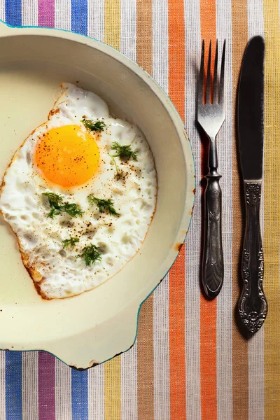 Natural fried egg on an old frying pan with an old knife and for — Stock Photo, Image