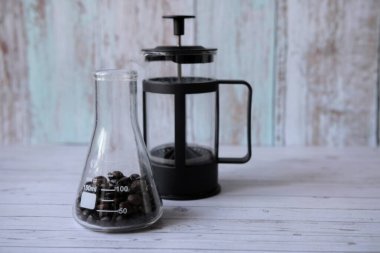 Kahve çekirdekleri şişenin içinde ve masada.