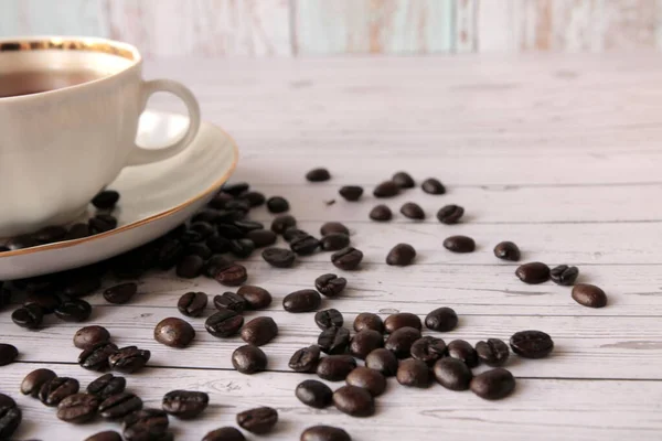 Una Taza Café Negro Granos Café Dispersos Mesa — Foto de Stock