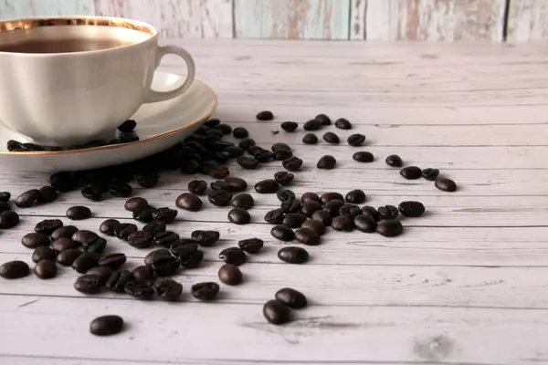 Una Taza Café Negro Granos Café Dispersos Mesa — Foto de Stock