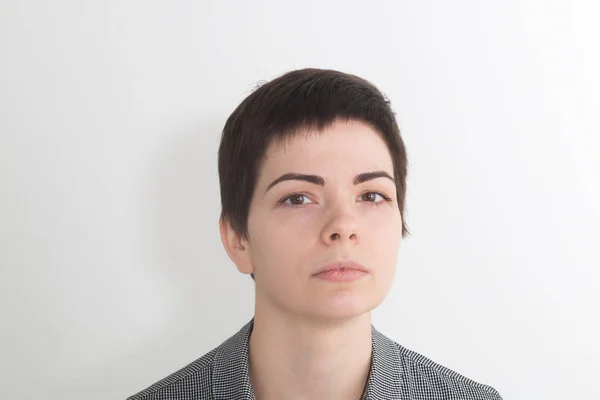 Yaramaz kadın tepeden bakıyor. Çekici kadın yargıç diğerleri. Kibirli gözleri üstünde tepe. Güzel esmer kadın yüz yakın çekim portre studio gri arka plan üzerinde izole