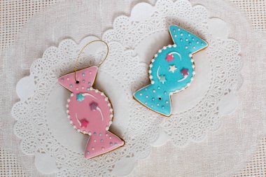 Beyaz peçete arka plan üzerinde şeker şeklinde iki gingerbread çerezleri. Üstten Görünüm, düz yatıyordu, kopya alanı. Kıvırcık Noel gingerbread ev yemekleri.