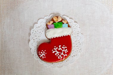 Noel gingerbread çorap peçete bir arka plan üzerinde hediyeler ile. Noel çorap zencefilli kurabiye, buzlanma ile dekore edilmiştir. Yeni yıl kavramı.