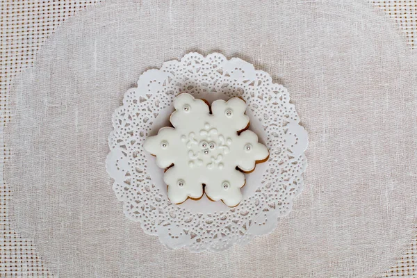 Noel gingerbread kar tanesi peçete bir arka plan üzerinde. Noel oyuncak zencefilli kurabiye, buzlanma ile dekore edilmiştir. Yeni yıl kavramı.