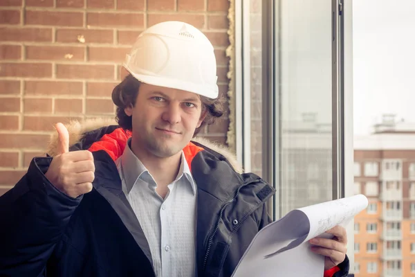 A construction worker gives you the thumbs up sign, signaling that everything is going well or the instruction was understood. Soft focus, toned.