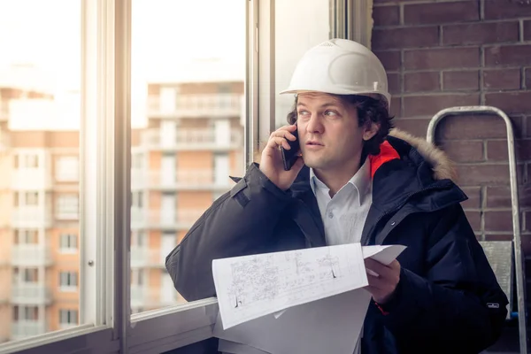 Mobile tarafından farklı projeler elinde tutarak söylüyorum endişeli tıraşsız Oluşturucusu portresi. İletişim ve iş kavramı. Yumuşak odak tonda,.