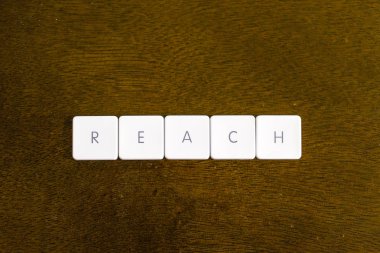 Plastik klavye alfabesi ile koyu arka plan üzerinde yazılı kelime ulaşmak