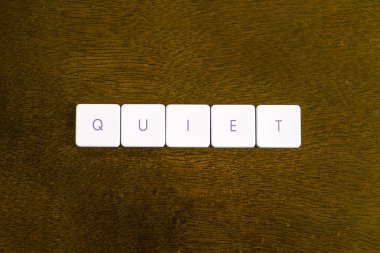 Sessiz kelime plastik klavye alfabesi ile koyu arka plan üzerinde yazılı