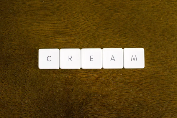 Cream Cuvânt Scris Alfabet Tastatură Din Plastic Fundal Întunecat — Fotografie, imagine de stoc