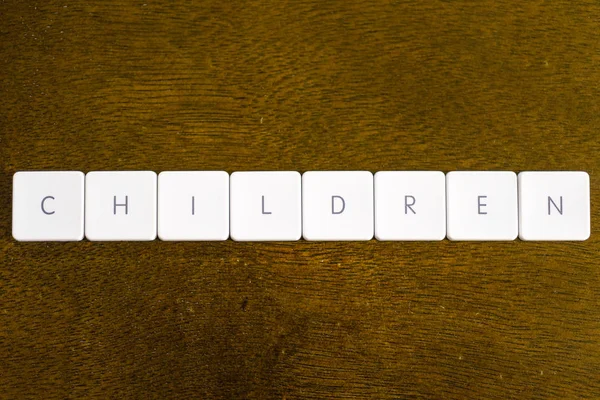 Παιδιά Λέξη Γραμμένη Πλαστικό Πληκτρολόγιο Αλφάβητο Σκούρο Φόντο — Φωτογραφία Αρχείου