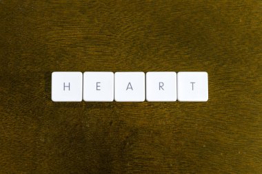 Plastik klavye alfabesi ile koyu arka plan üzerinde yazılı kalp kelime