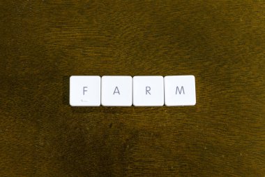 Çiftlik kelime plastik klavye alfabesi ile koyu arka plan üzerinde yazılı