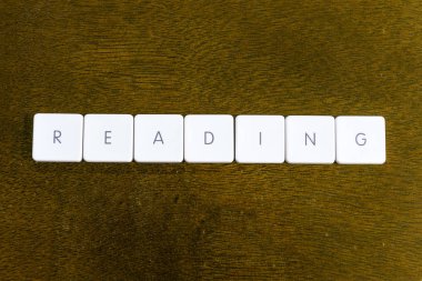 Plastik klavye alfabesi ile koyu arka plan üzerinde yazılı kelime okuma