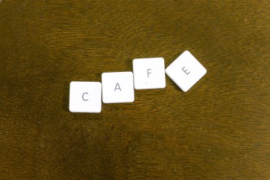 Plastik klavye alfabesi ile koyu arka plan üzerinde yazılı cafe kelime