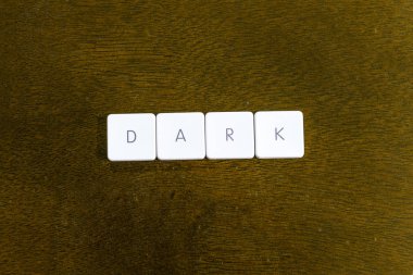 Karanlık kelime plastik klavye alfabesi ile koyu arka plan üzerinde yazılı