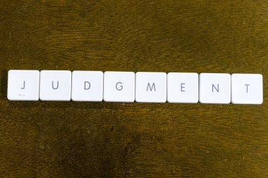 Plastik klavye alfabesi ile koyu arka plan üzerinde yazılı yargılama kelime