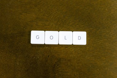 Altın kelime plastik klavye alfabesi ile koyu arka plan üzerinde yazılı