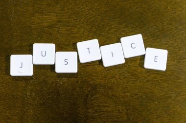 Plastik klavye alfabesi ile koyu arka plan üzerinde yazılı adalet kelime