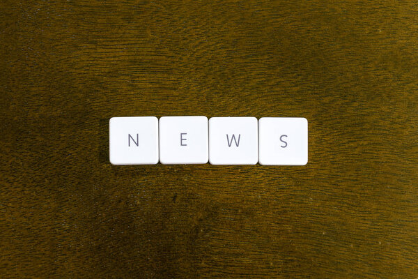 NEWS word written on plastic keyboard alphabet with dark background