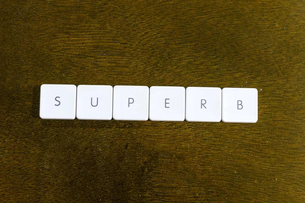 Superb Слово Написано Пластиковой Клавиатуре Алфавита Темным Фоном — стоковое фото