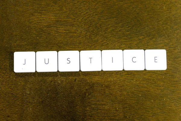 暗い背景でプラスチック製のキーボードは アルファベットで書かれた正義の言葉 — ストック写真