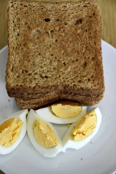 Whole wheat slice toasted bread with sliced boiled egg on the wh