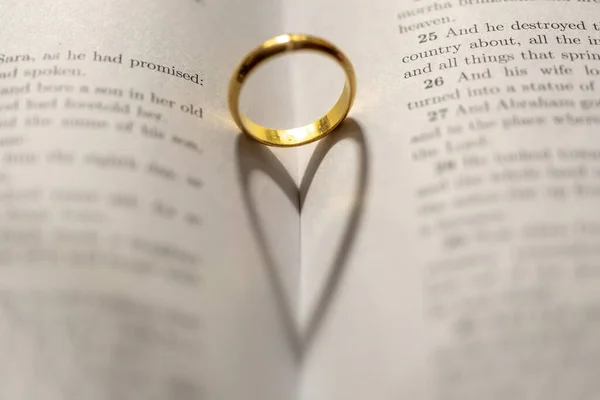 圣经上的结婚戒指页上有心形的阴影 — 图库照片