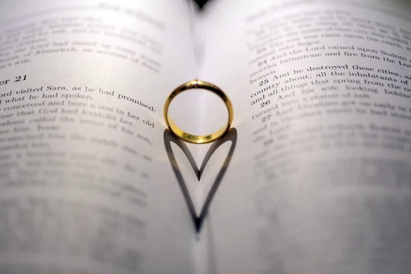 圣经上的结婚戒指页上有心形的阴影 — 图库照片