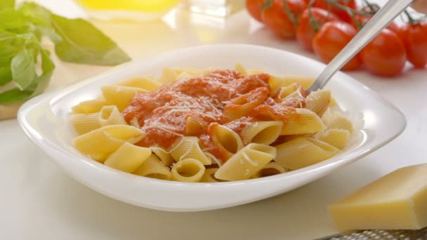Hot penne pasta with tomato sauce and cheese on a spoon — Stock Video
