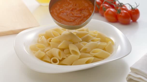 Att sätta tomatsås på penne pasta — Stockvideo