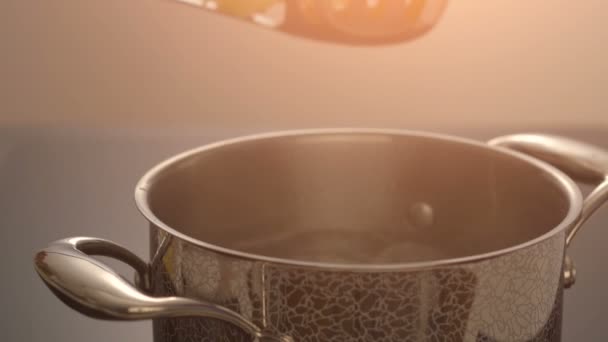 Положить макароны в кастрюлю с кипящей водой — стоковое видео