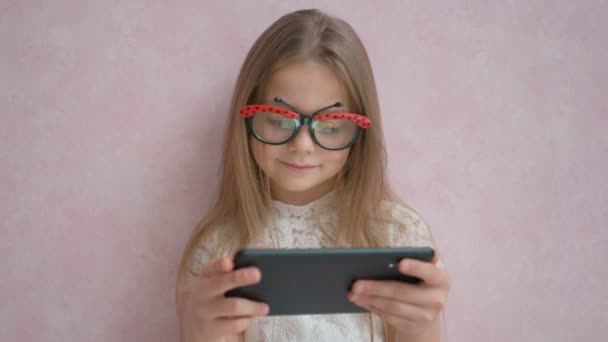 Engraçado menina jogando em um computador tablet em casa — Vídeo de Stock