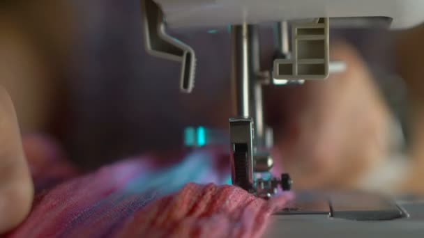 mains féminines tissu à coudre sur machine à coudre 