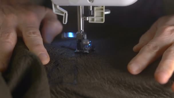 mains féminines tissu à coudre sur machine à coudre 