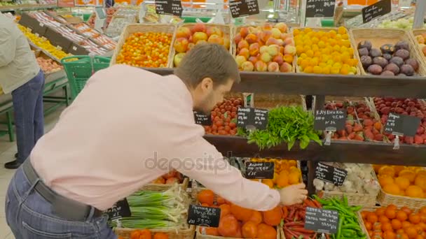 Hombre eligiendo un pimiento chile en el supermercado — Vídeos de Stock